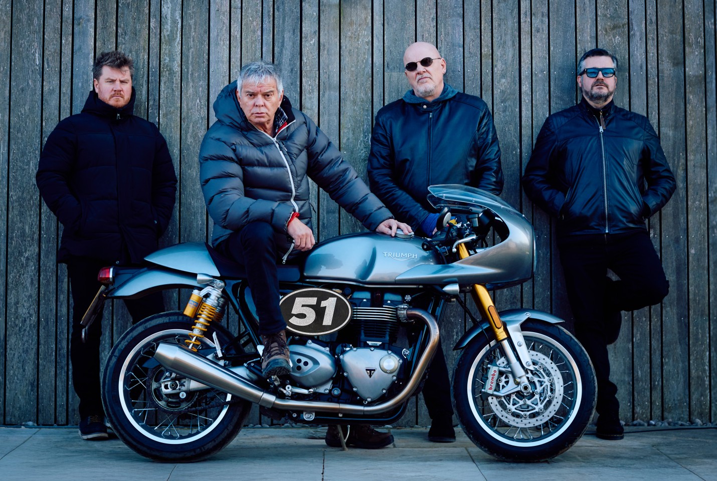 The Strangler's standing in front of a motorbike